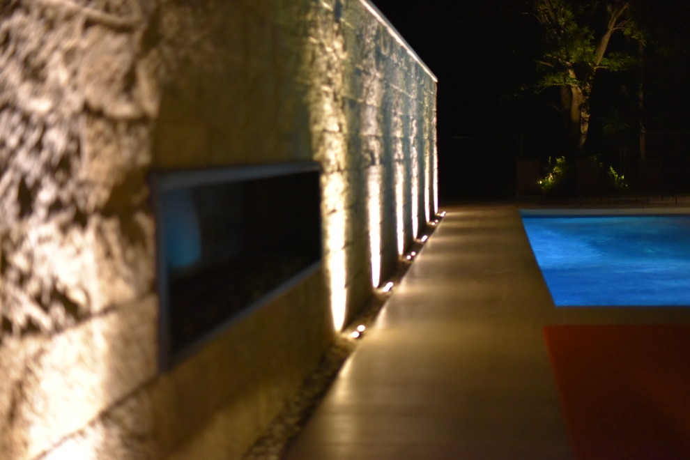 Immagine di una piscina monocorsia design rettangolare di medie dimensioni e dietro casa con lastre di cemento