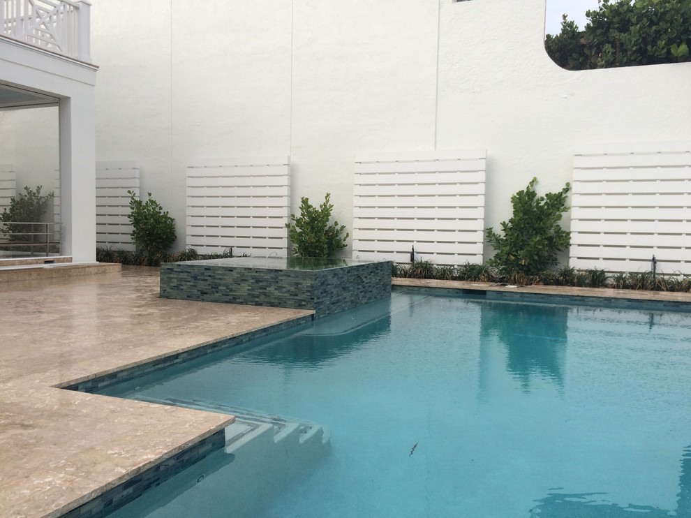 Cette photo montre une piscine à débordement et arrière moderne de taille moyenne et sur mesure avec un bain bouillonnant et du carrelage.