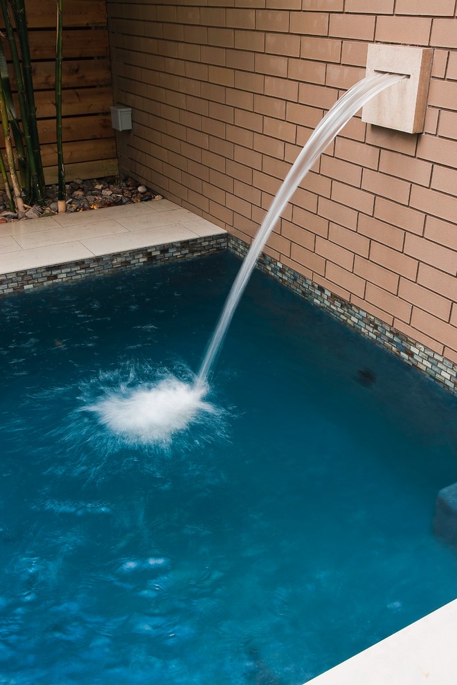 Foto di una piscina monocorsia minimal rettangolare di medie dimensioni e dietro casa con pavimentazioni in pietra naturale