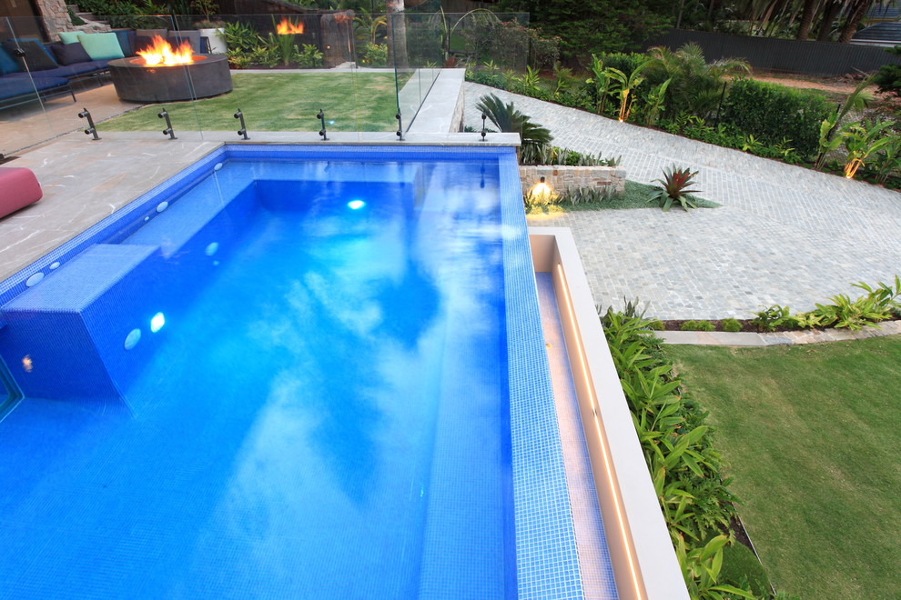 Idee per una grande piscina a sfioro infinito tropicale rettangolare davanti casa con piastrelle