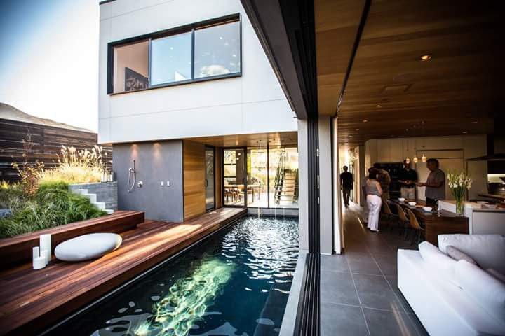 Diseño de piscina alargada actual de tamaño medio rectangular en patio trasero con entablado