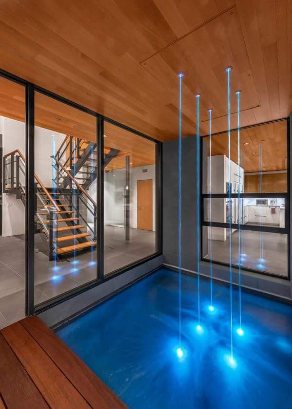 Foto di una piscina monocorsia minimal rettangolare di medie dimensioni e dietro casa con fontane e pedane
