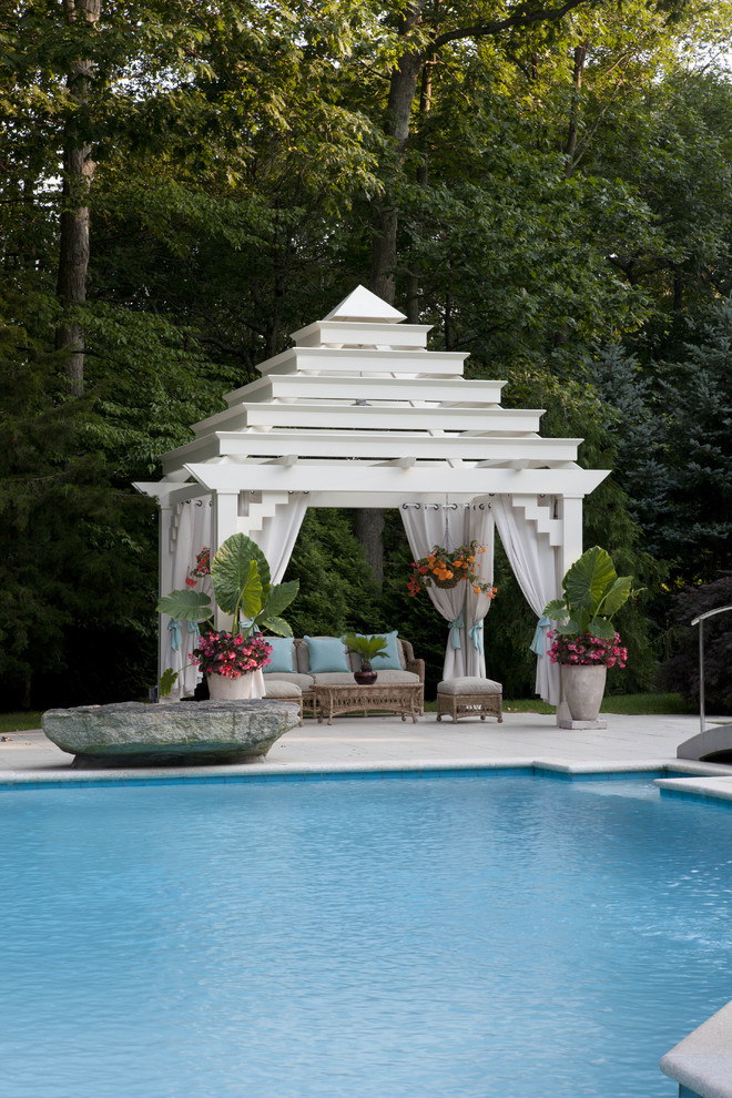 Diseño de piscina actual de tamaño medio a medida en patio trasero con losas de hormigón