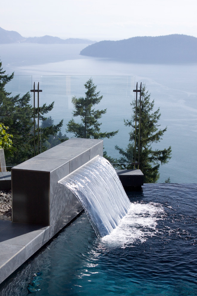 Immagine di una piscina a sfioro infinito minimal personalizzata dietro casa con fontane