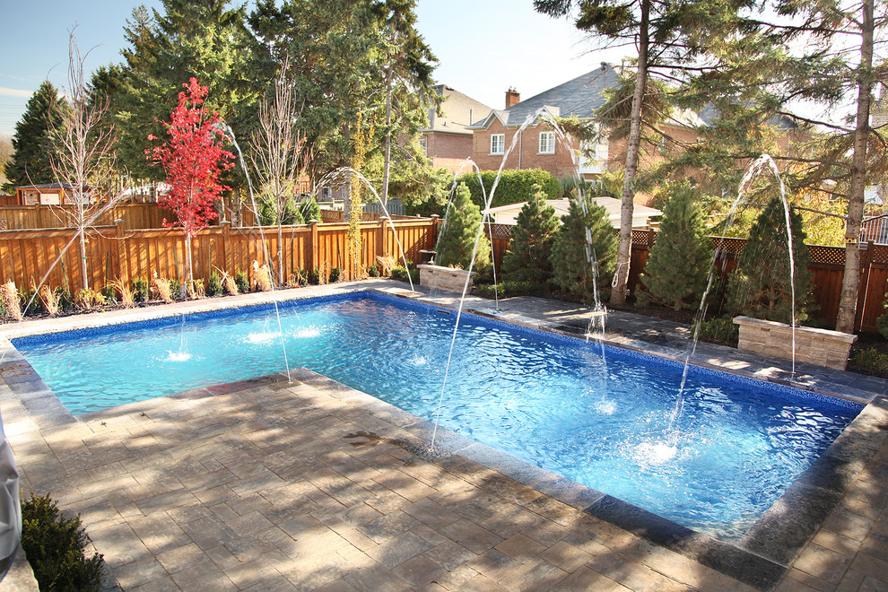 Inspiration for a large contemporary backyard concrete paver and l-shaped lap pool remodel in Toronto