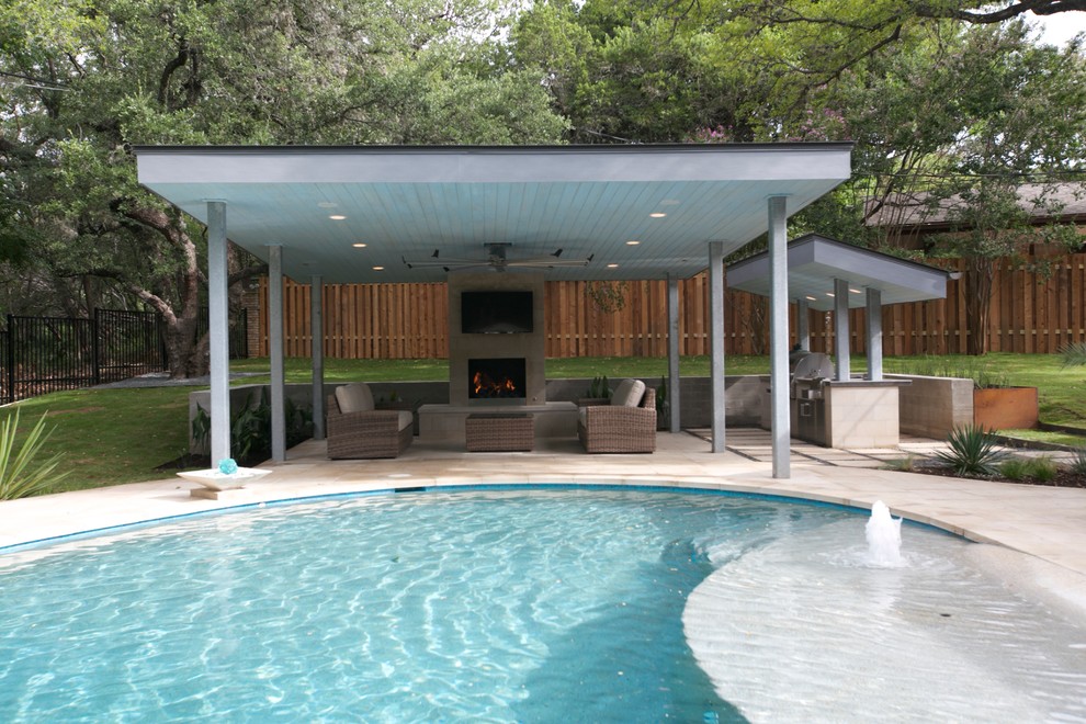Diseño de piscina con fuente natural contemporánea grande redondeada en patio trasero con adoquines de hormigón