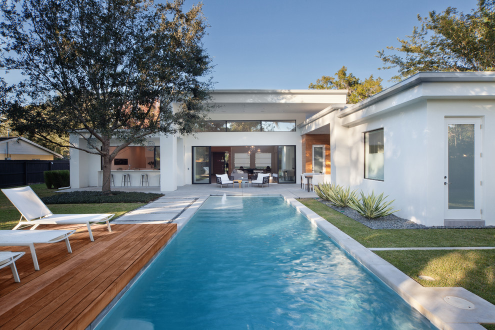 Diseño de piscina alargada contemporánea rectangular en patio trasero con entablado
