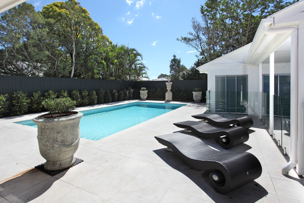 Свежая идея для дизайна: прямоугольный бассейн среднего размера на заднем дворе в современном стиле с забором - отличное фото интерьера