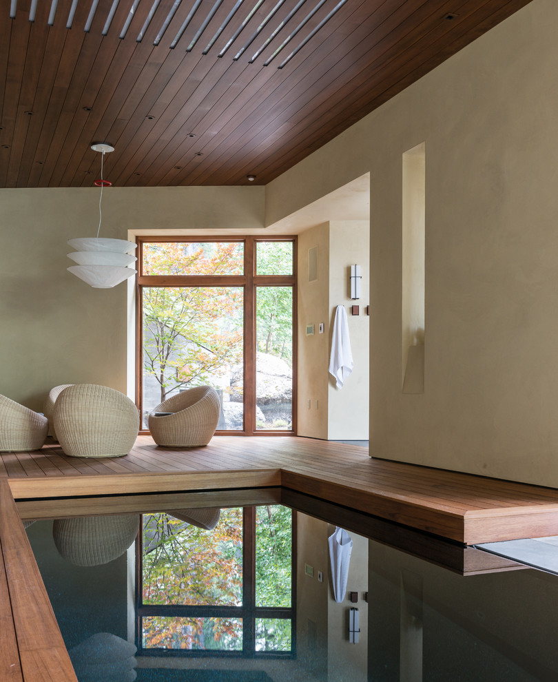 Cette image montre une piscine design avec une terrasse en bois.