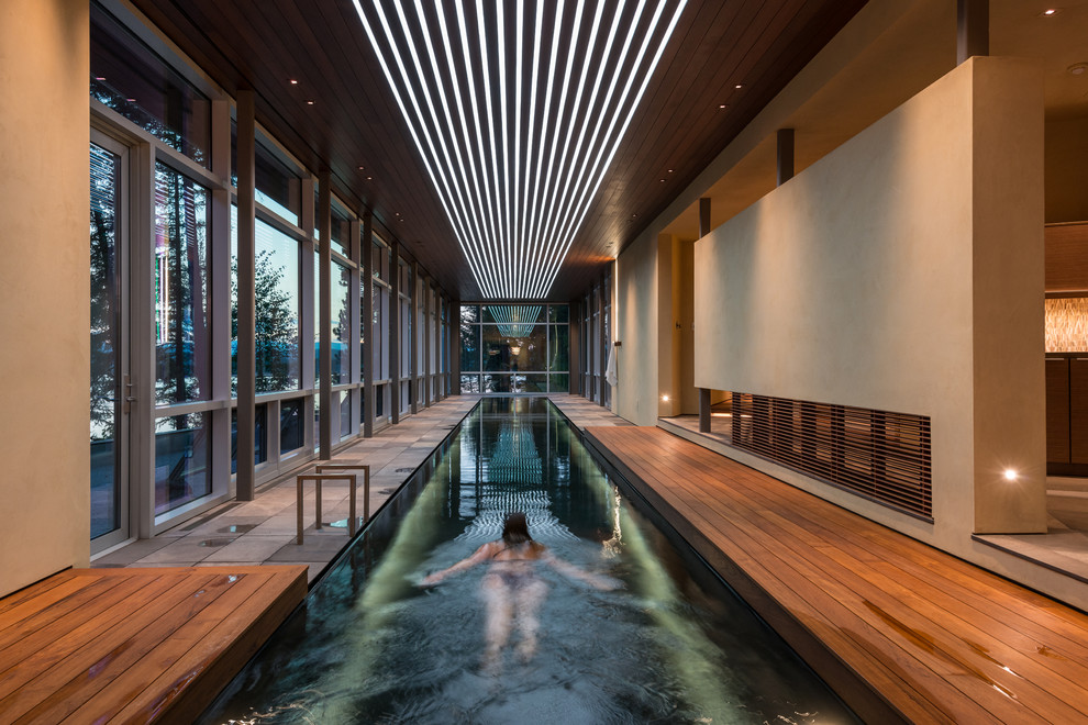 Cette photo montre une piscine tendance avec une terrasse en bois.