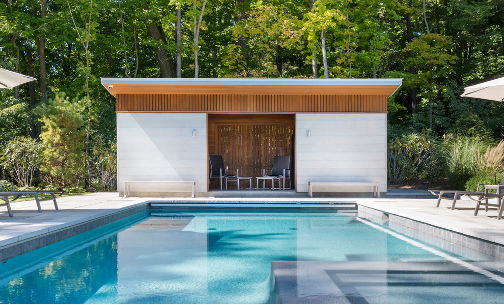 Foto de casa de la piscina y piscina actual pequeña rectangular en patio trasero con adoquines de hormigón
