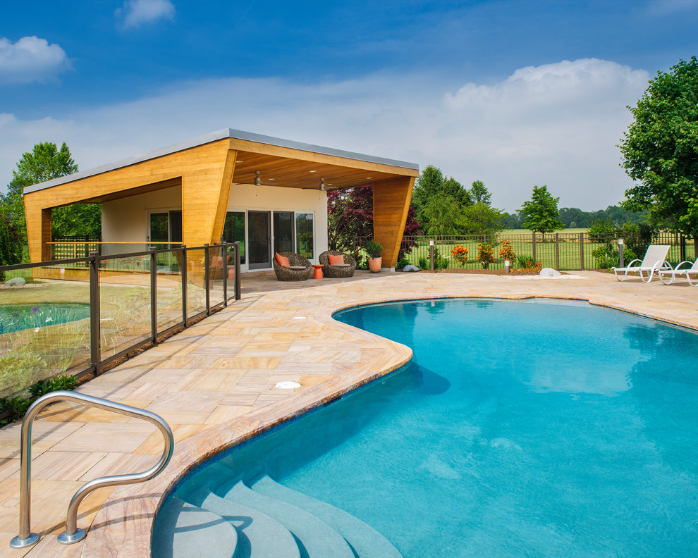Idéer för en stor modern pool på baksidan av huset, med naturstensplattor
