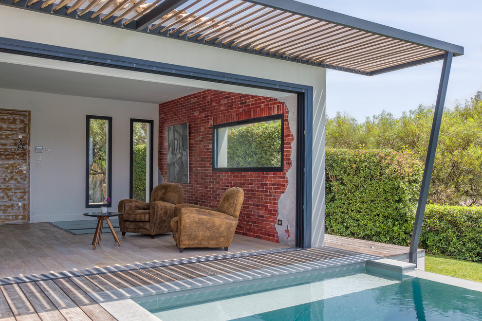Immagine di una piscina monocorsia minimal rettangolare dietro casa con una dépendance a bordo piscina e pedane