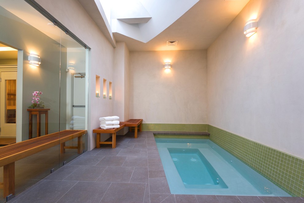 Идея дизайна: прямоугольный бассейн среднего размера в доме в современном стиле с джакузи и покрытием из каменной брусчатки