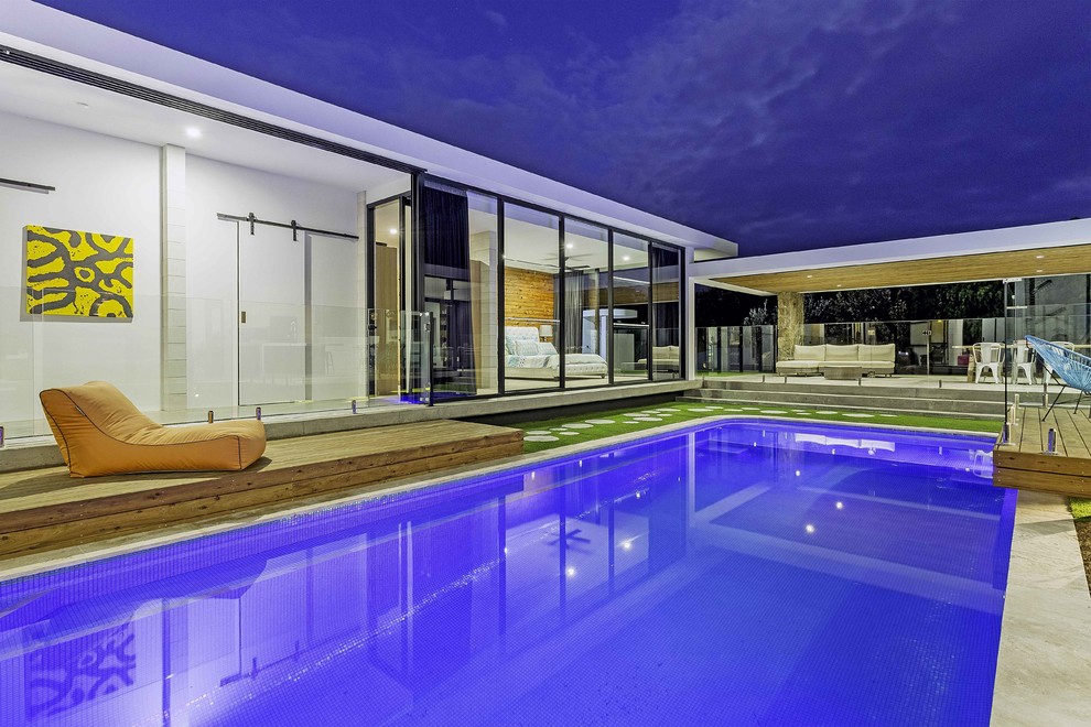 Imagen de casa de la piscina y piscina alargada contemporánea rectangular en patio con entablado