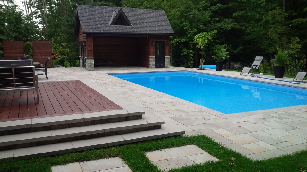 Modelo de casa de la piscina y piscina alargada contemporánea grande rectangular en patio trasero con adoquines de piedra natural