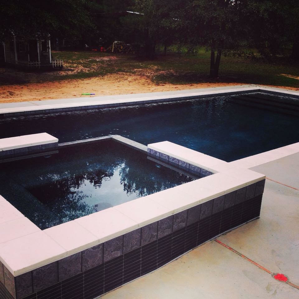 Photo of a large traditional back rectangular lengths hot tub in Houston with concrete slabs.