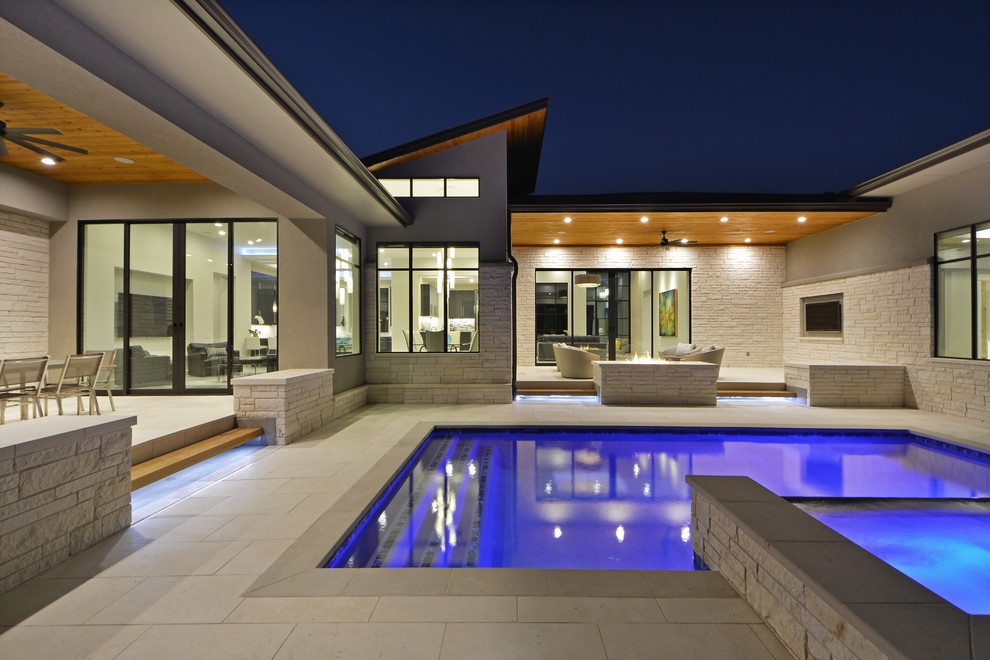 Ejemplo de piscinas y jacuzzis actuales rectangulares en patio con suelo de baldosas