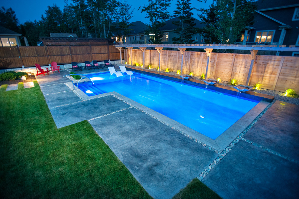 Идея дизайна: большой спортивный бассейн произвольной формы на заднем дворе в современном стиле с фонтаном и покрытием из декоративного бетона