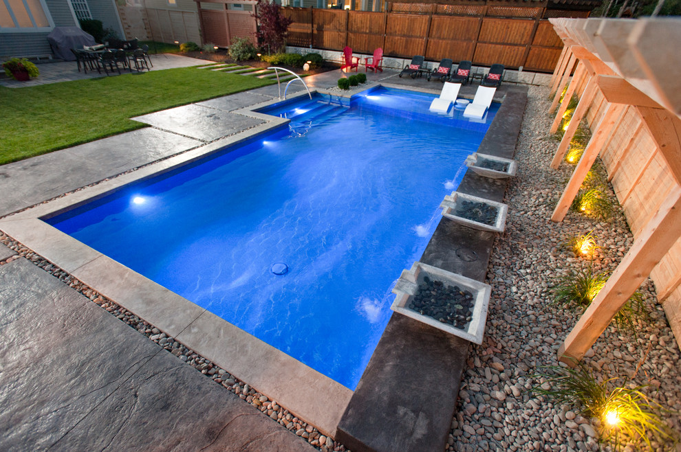 Inspiration for a large contemporary backyard stamped concrete and custom-shaped lap pool fountain remodel in Other