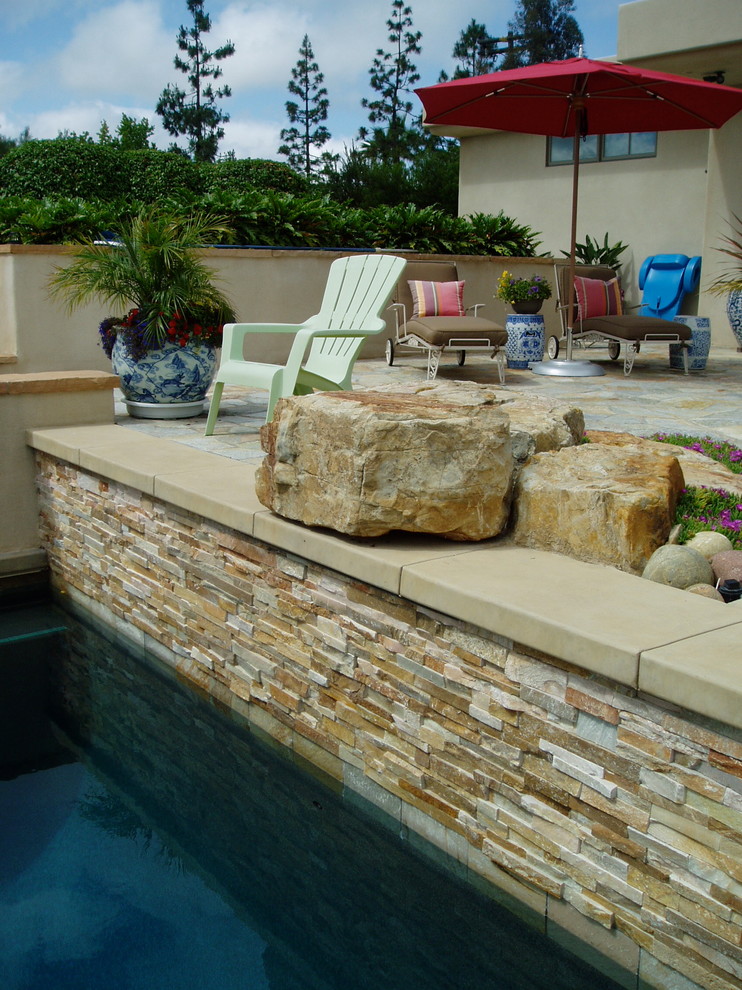 Imagen de piscina natural tradicional renovada grande rectangular en patio trasero con losas de hormigón