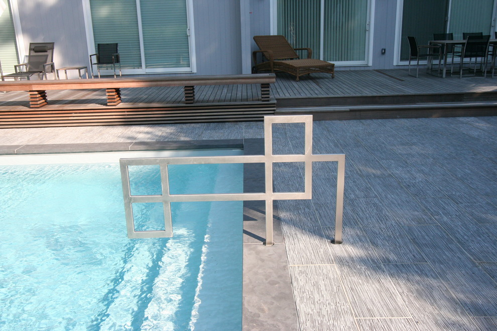 Стильный дизайн: прямоугольный бассейн среднего размера на заднем дворе в стиле модернизм с настилом - последний тренд