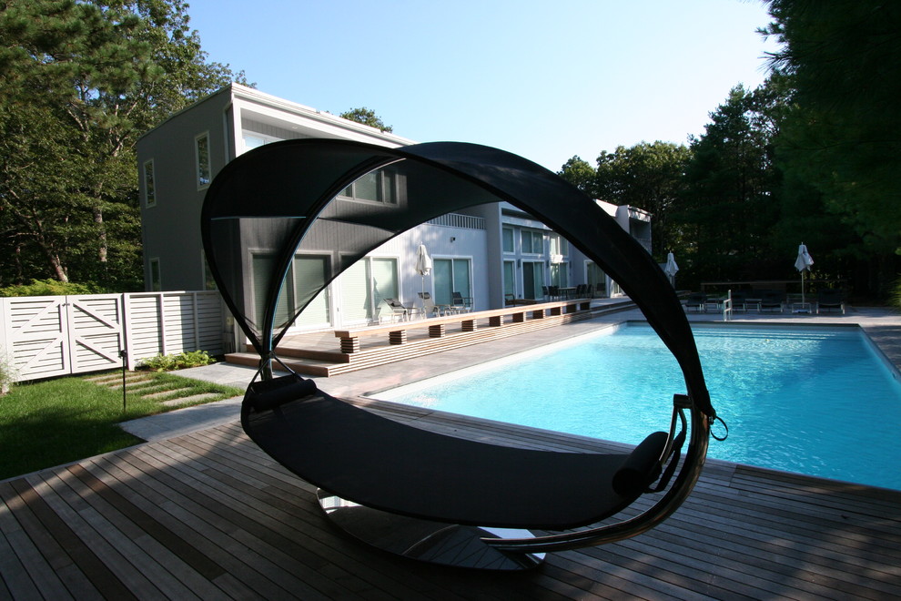 Aménagement d'une piscine arrière moderne de taille moyenne et rectangle avec une terrasse en bois.