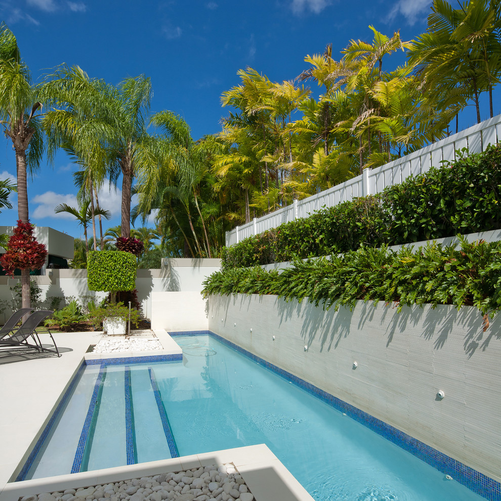 Photo of a medium sized contemporary back custom shaped lengths swimming pool in Other with tiled flooring and fencing.