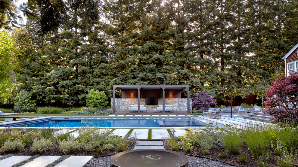 Modelo de piscinas y jacuzzis alargados contemporáneos extra grandes rectangulares en patio trasero con adoquines de piedra natural