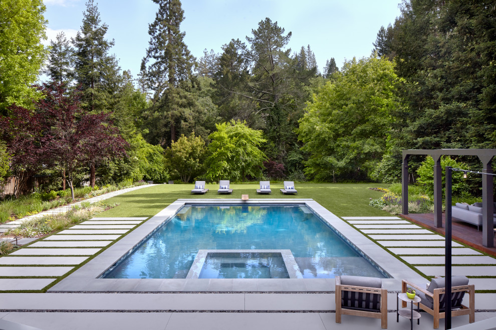 Свежая идея для дизайна: огромный спортивный, прямоугольный бассейн на заднем дворе в современном стиле с джакузи и покрытием из каменной брусчатки - отличное фото интерьера