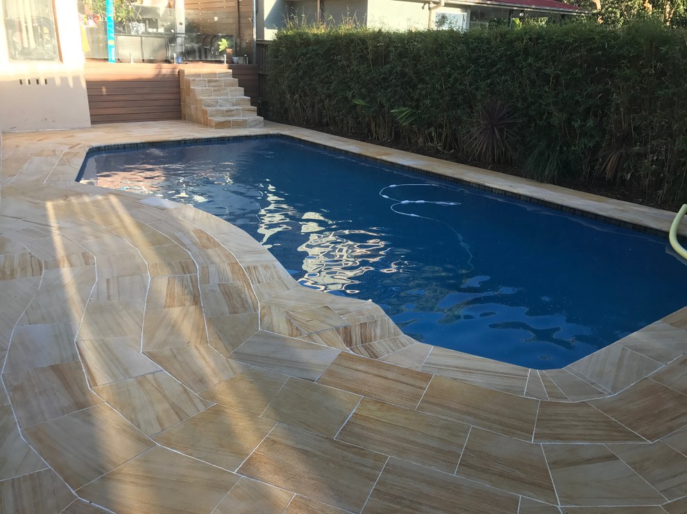 Ispirazione per una piscina monocorsia minimal personalizzata di medie dimensioni e dietro casa con pavimentazioni in pietra naturale