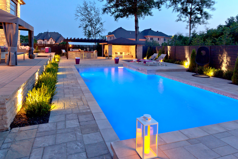 На фото: прямоугольный бассейн в современном стиле с мощением тротуарной плиткой с