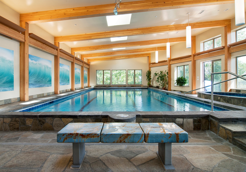Immagine di una piscina coperta contemporanea rettangolare con pavimentazioni in pietra naturale