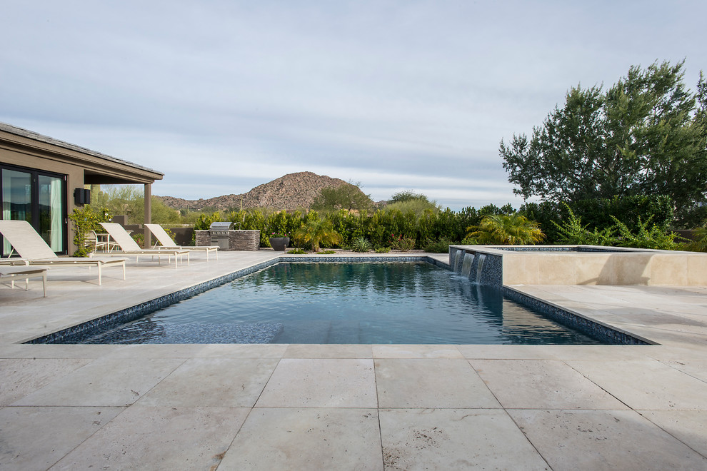 Idee per una piscina monocorsia design rettangolare di medie dimensioni e dietro casa con fontane e pavimentazioni in pietra naturale