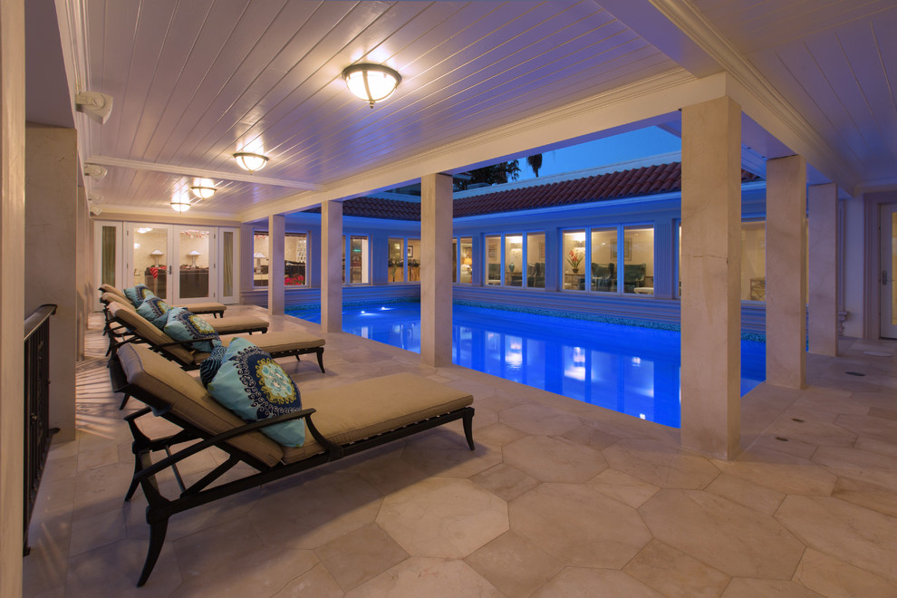 Ejemplo de piscina alargada tropical de tamaño medio rectangular en patio con adoquines de piedra natural