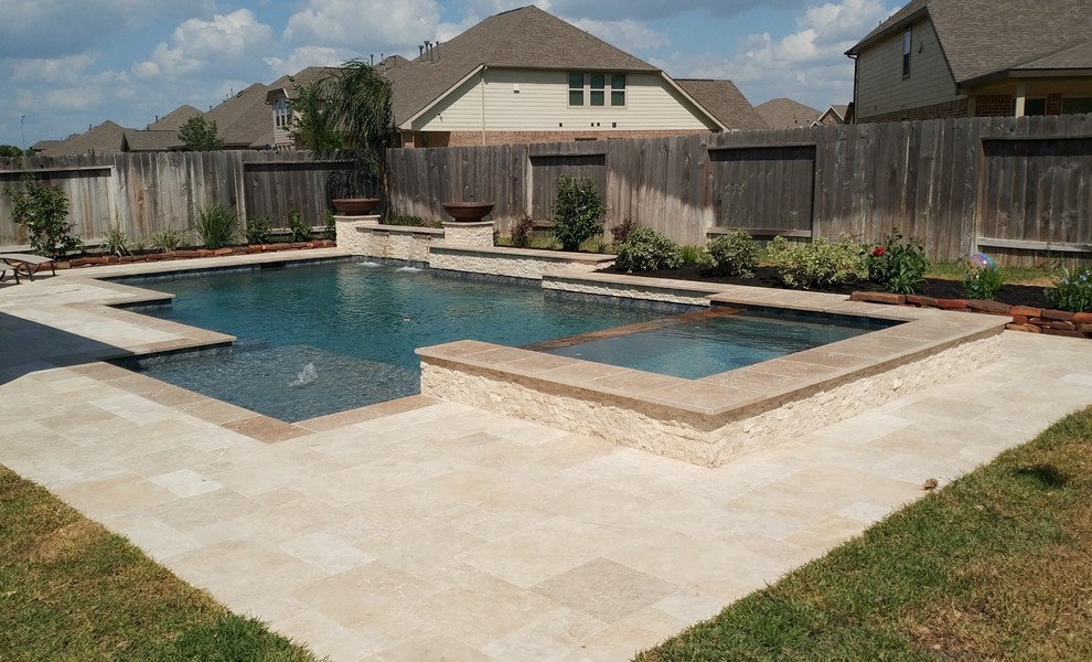 Ispirazione per una grande piscina monocorsia chic rettangolare dietro casa con una vasca idromassaggio e pavimentazioni in pietra naturale
