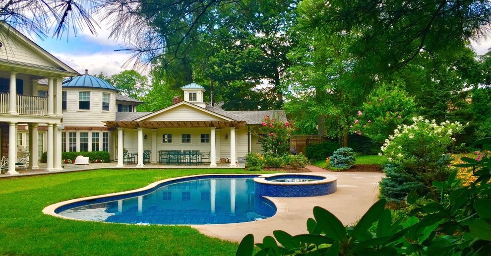 Foto de piscinas y jacuzzis eclécticos grandes tipo riñón en patio trasero con adoquines de piedra natural