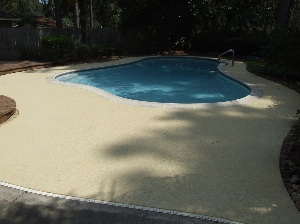 Klassischer Schwimmteich hinter dem Haus in individueller Form mit Stempelbeton in Houston