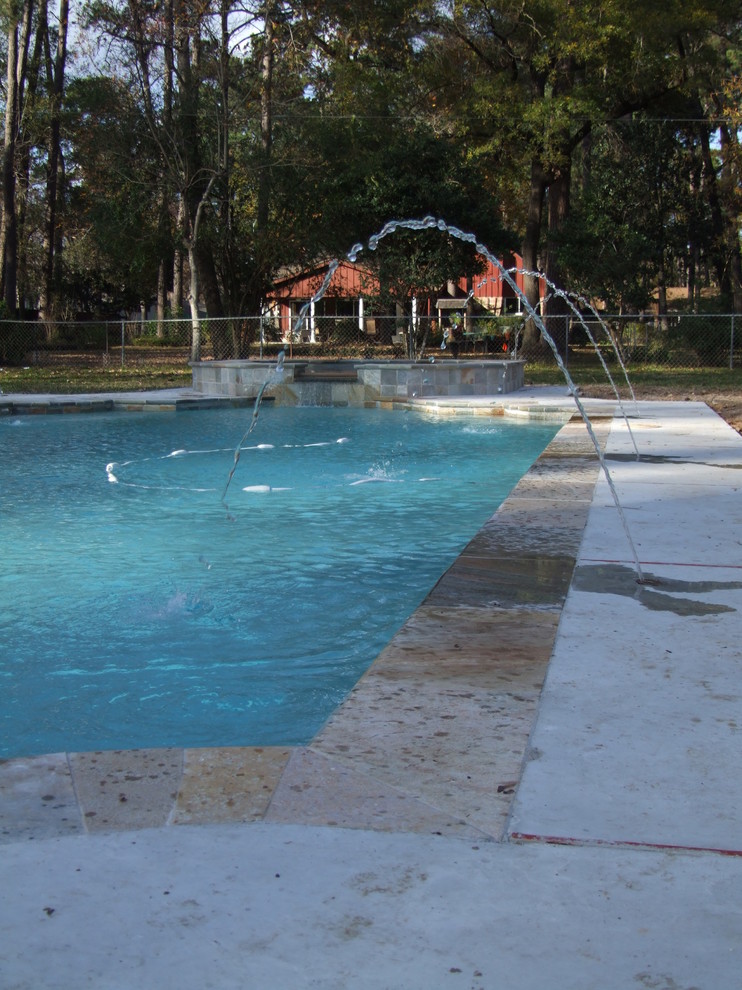 Immagine di una piscina chic dietro casa con fontane