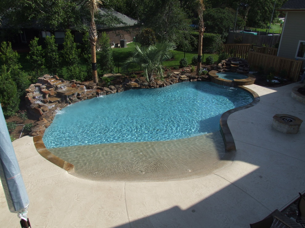 Cette image montre une piscine naturelle et latérale ethnique sur mesure avec du béton estampé.