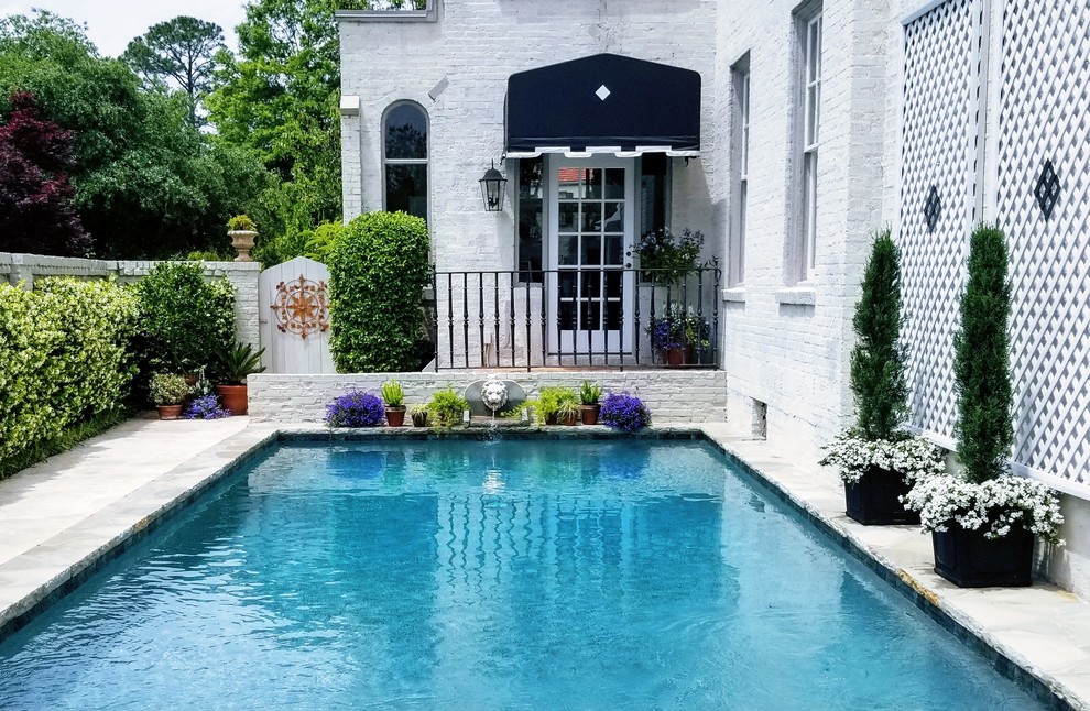 Diseño de casa de la piscina y piscina alargada tradicional pequeña rectangular en patio con adoquines de piedra natural