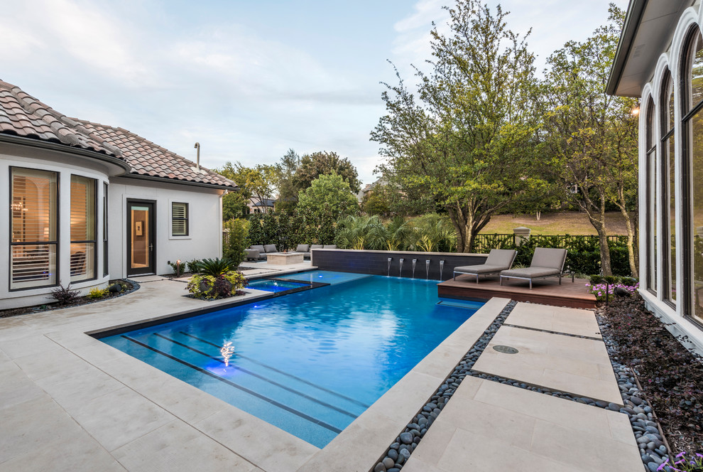 Foto de piscinas y jacuzzis alargados clásicos renovados de tamaño medio a medida en patio trasero con adoquines de piedra natural