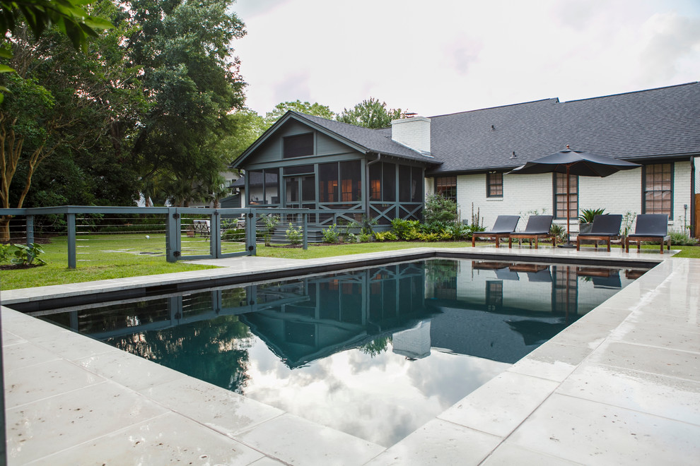 Ejemplo de casa de la piscina y piscina actual de tamaño medio rectangular en patio trasero con adoquines de hormigón