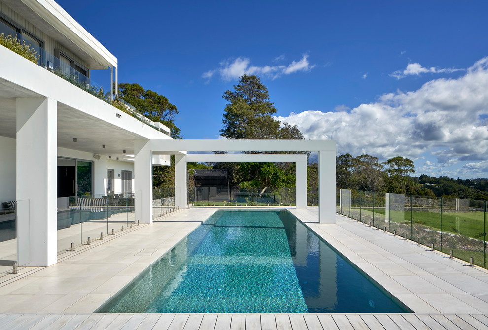 Foto de piscina alargada contemporánea grande rectangular en patio trasero con entablado