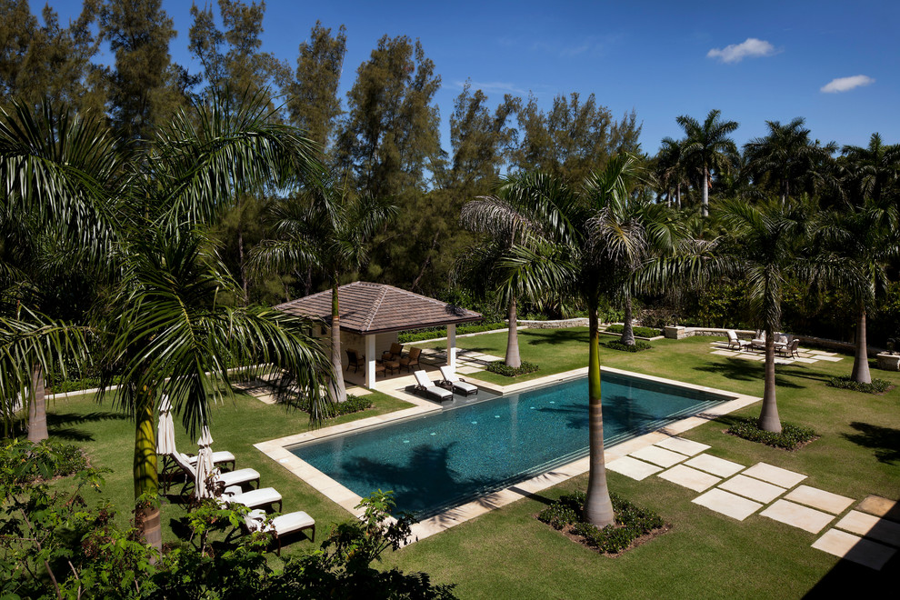 Immagine di una piscina naturale tropicale rettangolare di medie dimensioni e dietro casa con pavimentazioni in cemento
