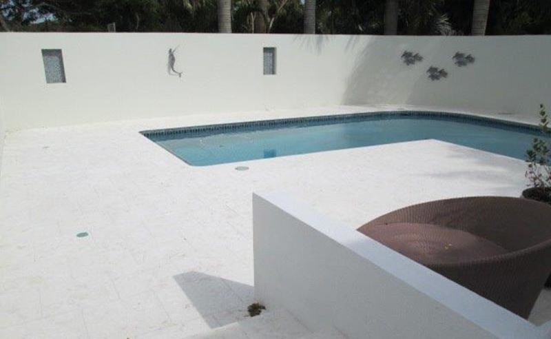 Foto di una piscina tropicale dietro casa con piastrelle