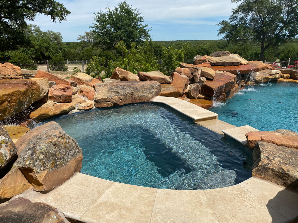 На фото: огромный естественный бассейн произвольной формы на заднем дворе в стиле рустика с перегородкой для приватности и настилом