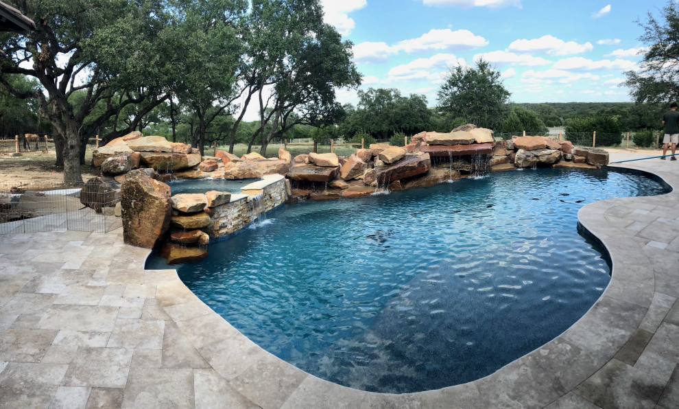 Imagen de piscina natural rústica extra grande a medida en patio trasero con privacidad y entablado