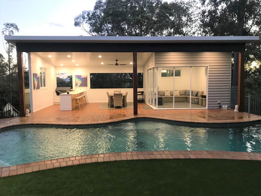 Immagine di una grande piscina moderna personalizzata dietro casa con una dépendance a bordo piscina e pedane