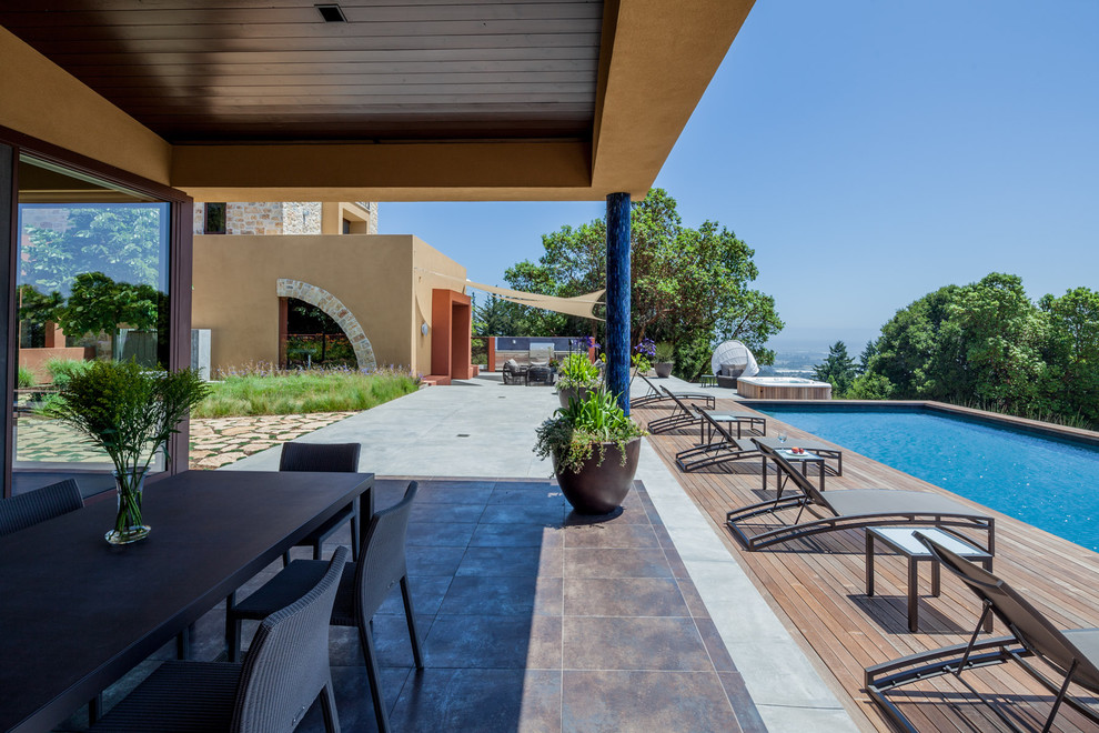 Imagen de casa de la piscina y piscina contemporánea grande rectangular en patio trasero con suelo de baldosas